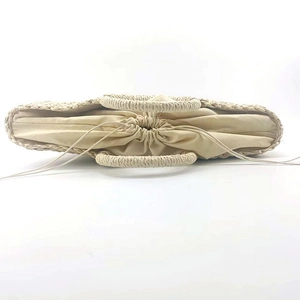 Top view of half-moon straw tote bag showing drawstring lining and woven handles