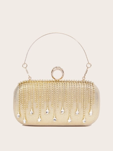 Detail of gold evening clutch with rhinestone tassels and circular metal handle
