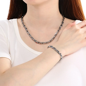 Close-up of a female model wearing a silver stainless steel square box chain necklace and bracelet