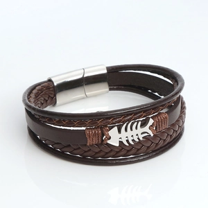 Detail of brown multilayer braided leather bracelet with silver fishbone metal charm