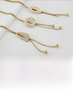 Detail of gold geometric necklaces with rhinestones and square snake chains on white