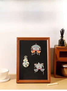 Close-up of a vintage wood magnetic frame displaying Chinese enamel pins on black lining