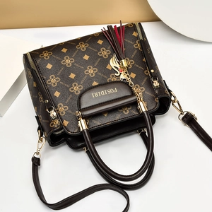 Brown monogram handbag with gold hardware, tassel charm and adjustable strap for women