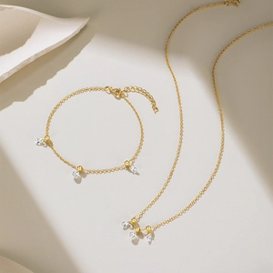 Detail of gold-plated silver jewelry set featuring teardrop-shaped zircon pendants