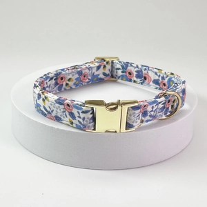 Floral pet collar with gold metal buckle and D-ring on white display stand