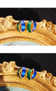 Detailed close-up of blue and green enamel earrings with gold metallic curved lines