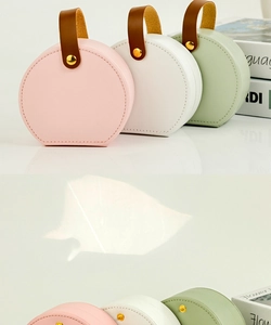 Detailed view of portable leather jewelry boxes in pink, white, and pale green colors