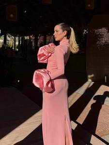 Détail d'une robe longue moulante rose avec volants floraux 3D et fente sur le côté