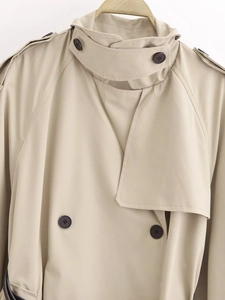 Dettaglio del trench kaki con bottoni a doppio petto e spalline decorative classiche