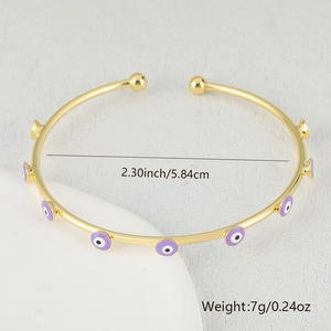 Macro view of gold evil eye cuff bracelet showing diameter and weight specifications