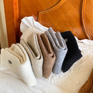 Close-up of five pairs of thick thermal socks with delicate flower embroidery