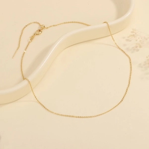 Detail of the 18K gold-plated adjustable chain with lobster clasp and sliding bead