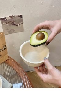 Close-up of a cream ceramic dining bowl being used in a cozy home setting with food