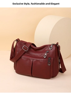 Detailed view of burgundy multi-pocket shoulder bag with smooth texture and zippers