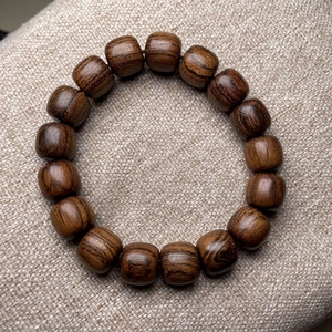 Tiger skin sandalwood beaded bracelet with natural grain on textured fabric