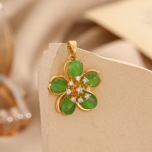 Macro detail of a vintage flower pendant with green cat-eye stone petals and gold frame