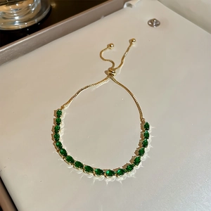 Bracelet doré ajustable orné d'une rangée de pierres en zircone vertes ovales de 3mm