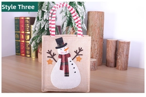 Détail du sac cadeau de Noël en toile de jute avec motif bonhomme de neige et anses