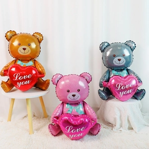 Three teddy bear foil balloons in brown, pink, and grey holding Love You heart balloons
