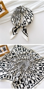 Detail showing the black and white geometric pattern and satin texture of the 70cm silk scarf