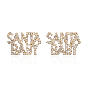 Detail of golden SANTA BABY letter earrings with white rhinestones on white backdrop