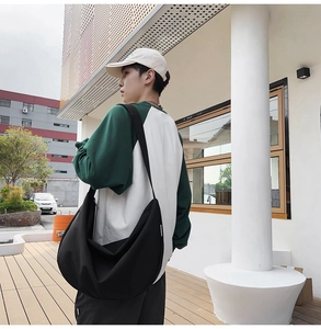 Large black crescent oxford shoulder bag shown on model for a casual outdoorsy daily look