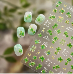 Macro shot of clover nail stickers with 3D texture and green gradient nail art samples