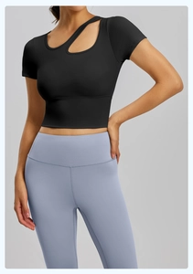 Dettaglio del top sportivo nero aderente con scollatura cut-out e leggings blu yoga