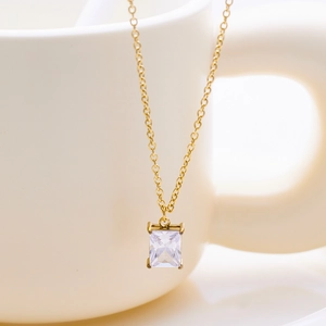 Detailed macro shot of a gold necklace featuring a classic rectangular zircon pendant