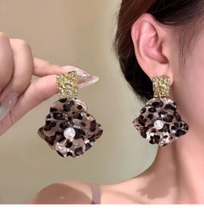 Detail of leopard print acetate flower earrings with pearls and gold hammered metal studs