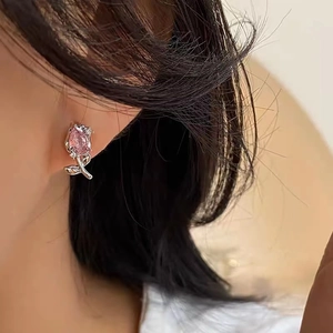 Detail of pink crystal tulip earring with diamond leaf worn by a model