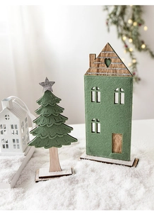 Détail d'une maison de Noël en feutre vert et mini sapin sur base de neige réaliste