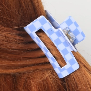 Pince à cheveux à damier bleu et blanc de 9 cm sur de longs cheveux châtains roux