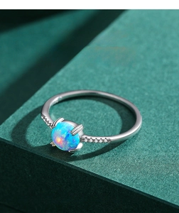 Macro detail of S925 silver opal ring with side diamonds on dark green textured steps