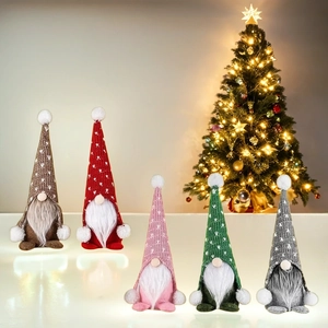 Vue détaillée de cinq gnomes de Noël avec chapeaux tricotés à cœurs sur une table blanche