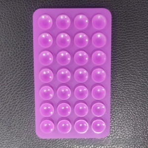 Macro detail of purple silicone suction pad with 28 suction cups on a black surface