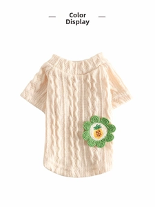 Macro detail of cream knit dog vest featuring cable pattern and pineapple flower patch