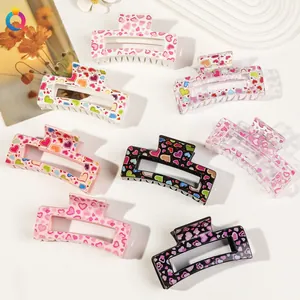 Macro shot of 8 square hair claws with colorful heart prints and LOVE text on a white base