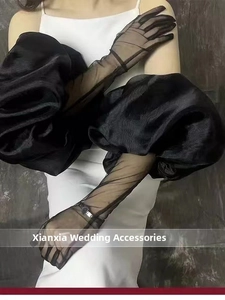 Detail of elegant black sheer wedding gloves with dramatic tulle puff sleeve accents