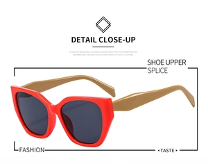 Detail close-up of cat-eye sunglasses with red frames and metallic gold temples