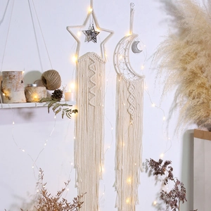 Detail of star and moon macrame wall hangings with glowing LED lights and cotton tassels