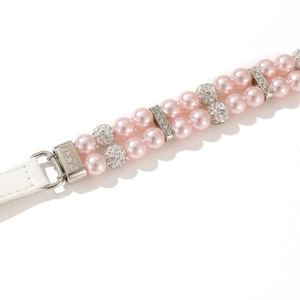 Macro detail of a double-row pink pearl pet collar with rhinestone accents and silver buckle