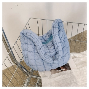 Macro shot of light blue quilted puffy tote bag in a metal shopping cart context