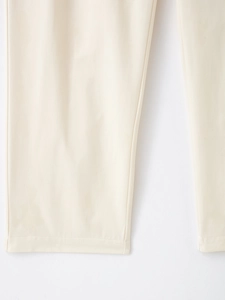 Gros plan détaillé des coutures fines et de la texture du tissu sur l'ourlet du pantalon