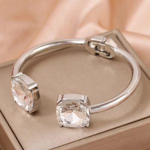 Polished silver hinge bangle with large square crystals on a luxury display box