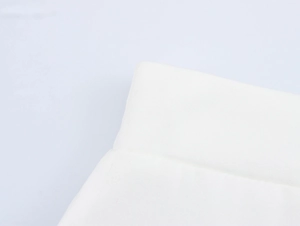 Macro detail of the high-quality white twill fabric texture and fine stitching on the skirt