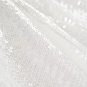 Detail aus weißem Paillettenstoff eines sexy Partykleides mit schimmernden Pailletten