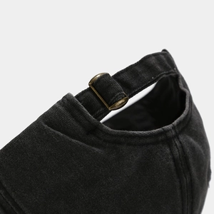 Detail of vintage bronze metal buckle and washed fabric strap on baseball cap