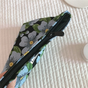 Detail shot of vintage blue floral jacquard canvas bag with quality black zipper closure