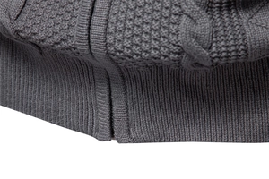 Dettaglio macro del cardigan grigio da uomo con trama a nido d'ape e zip centrale